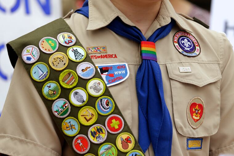 Merit badges and a rainbow-colored neckerchief slider are affixed on a Boy Scout uniform outside the headquarters of Amazon in Seattle.