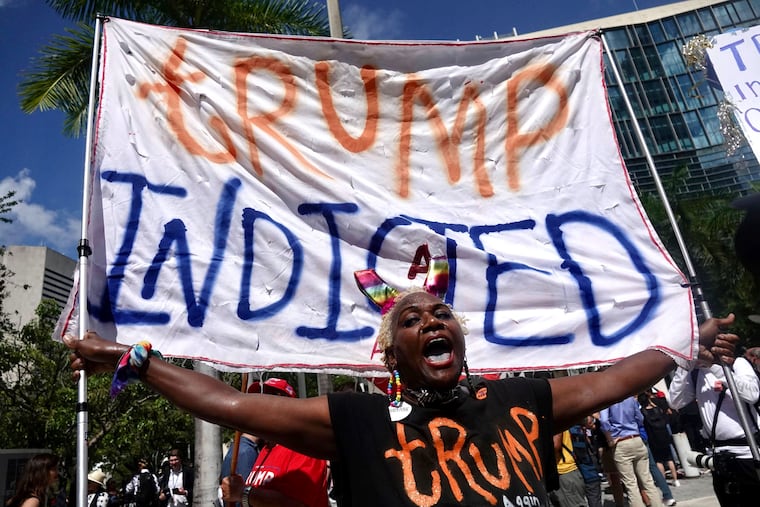 Nadine Seiler held a banner reading "Trump indicted" outside the Wilkie D. Ferguson Jr. U.S. Courthouse Tuesday while former President Donald Trump made a federal court appearance on dozens of felony charges.