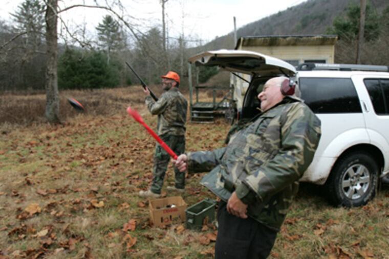 Mike Grasso (right), 65, throws clay targets for Bob Loughery (left), 46. (David Swanson / Staff Photographer)