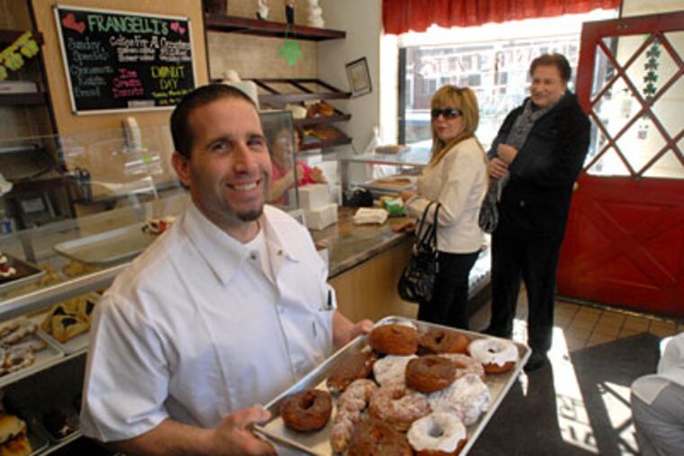 At Frangelli's Bakery, owner John Colosi with a tray of doughnuts. (APRIL SAUL / Staff Photographer)