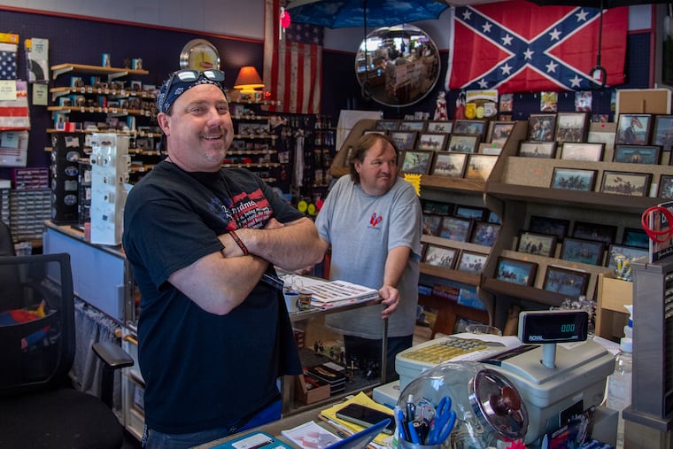 Erik Crist (left) and Chet Crist at their shop, Flex and Flannigan's, in Gettysburg, Pa. He welcomes the renewed push for flag bans, because he sells more of them.