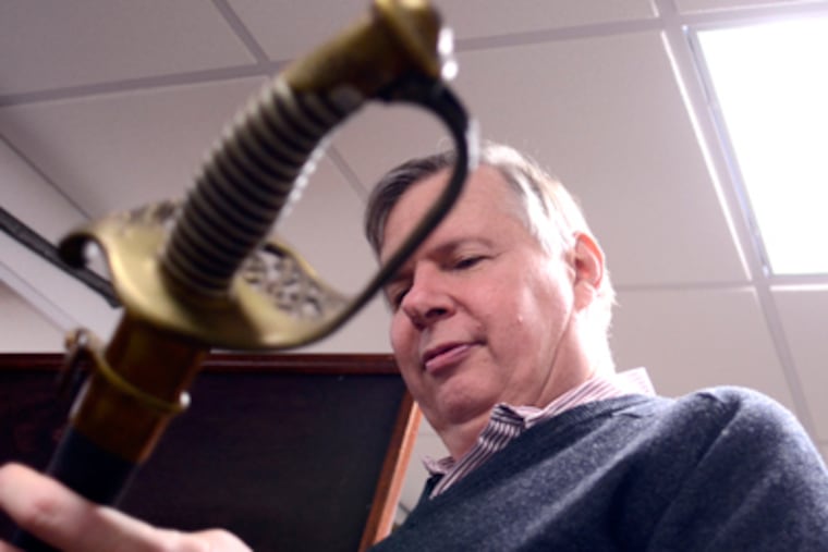 Historian and author Paul Loane with his ancestor's sword, in his Mt. Holly home November 1, 2011 where he has loaned parts of his large collection of Civil War artifacts. ( TOM GRALISH / Staff Photographer )
