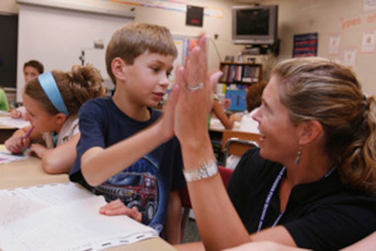 Ryan Andes and fifth-grade teacher Jenna Roberts celebrate the completion of a writing assignment at Chadds Ford Elementary.