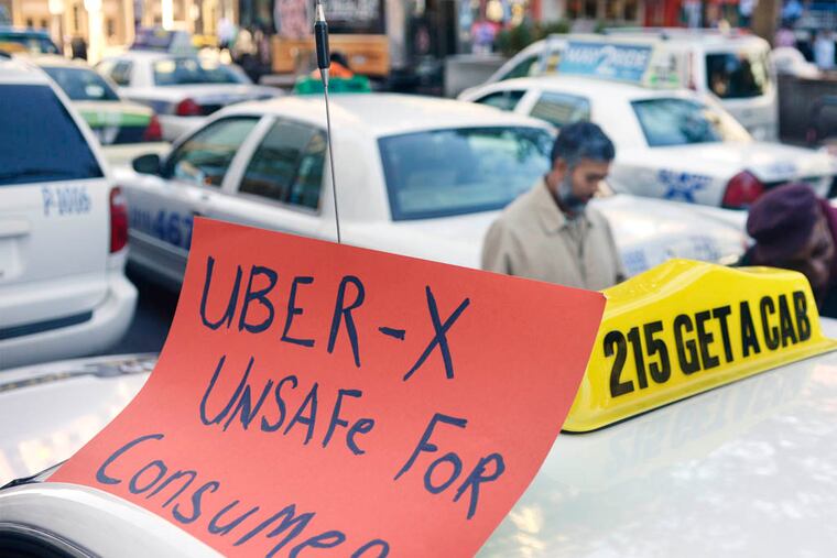 Drivers with the Taxi Workers Alliance of Pennsylvania protest on JFK Blvd, near LOVE Park October 8, 2014, as Uber and Lyft are making a concerted push to bring their ride-share services to Philadelphia. ( TOM GRALISH / Staff Photographer )