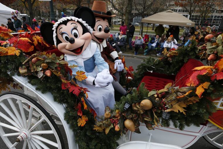 Minnie and Mickey Mouse ride a carriage along the Ben Franklin Parkway during the 2016 Thanksgiving Day parade in Philadelphia.