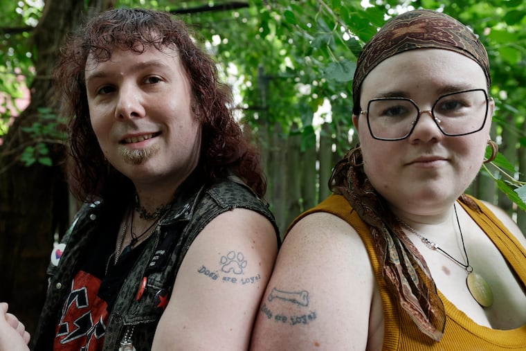 Travis Curhart-Higgins (left) and Linden Curhart show the tattoos they got after their wedding in 2023.