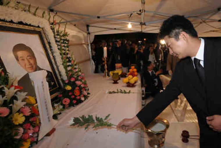 The son of ex-President Roh Moo-hyun, Roh Gun-ho, places a flower before his father's portrait.