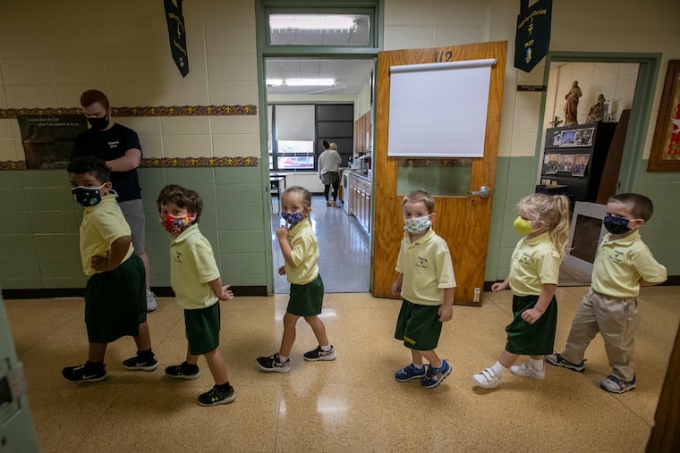 Students with face masks walk through the hallway at Nativity of Our Lord School in Warminster in September.