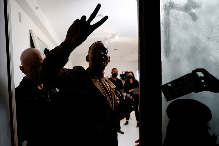 Performer Will Smith raises his fingers while visiting Harriett's Bookshop in Fishtown.