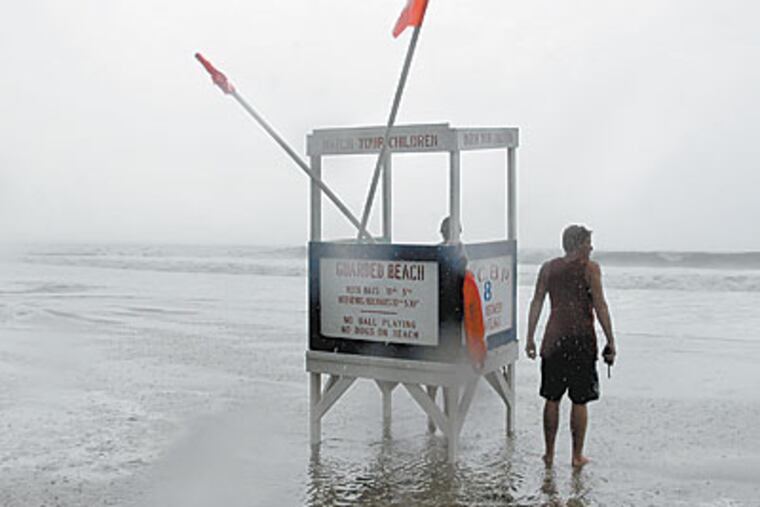 Ocean City lifeguards keep watch as high surf kicked up by Hurricane Bil lpushes pass his lifeguard stand. (Ron Tarver / Staff Photographer)