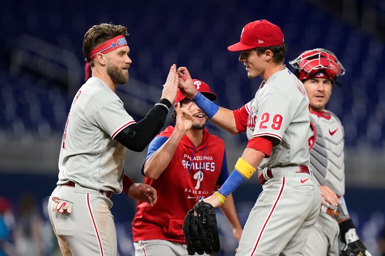 The Phillies' Bryce Harper (left) and Nick Maton high-five after Tuesday's 2-1 win in Miami.