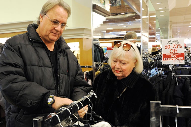 Craig Braverman (left) assists his mother-in-law Elaine Barsky in shopping for a winter coat at the Boscov's store in the Neshaminy Mall in Bensalem.