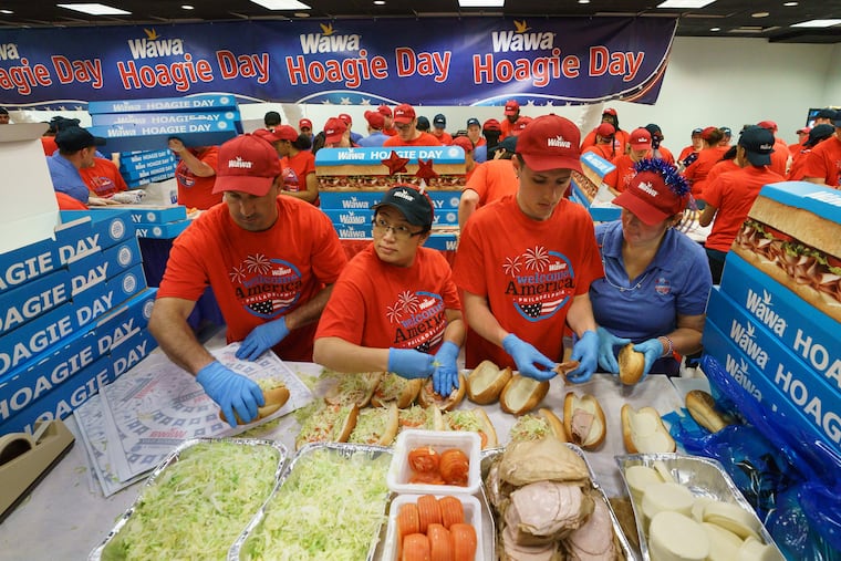 (Left to right) Rob Mitchell, Sherly D'Alfonso, Seth Williams, and Melissa Williams make hoagies for Wawa's annual hoagie day, during which the convenience chain will build and give away 32,000 hoagies, at the National Constitution Center.