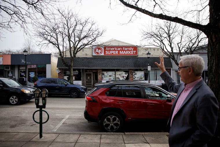 Narberth Mayor Dana Edwards gestures toward empty storefronts along Haverford Avenue in his town in January.