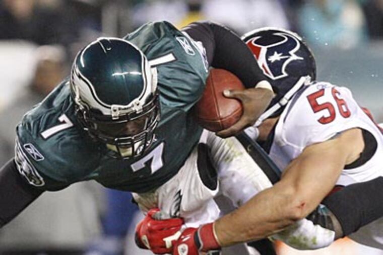 Michael Vick gets hit by the Texans Amobi Okoye in the second quarter. (David Maialetti / Staff Photographer)