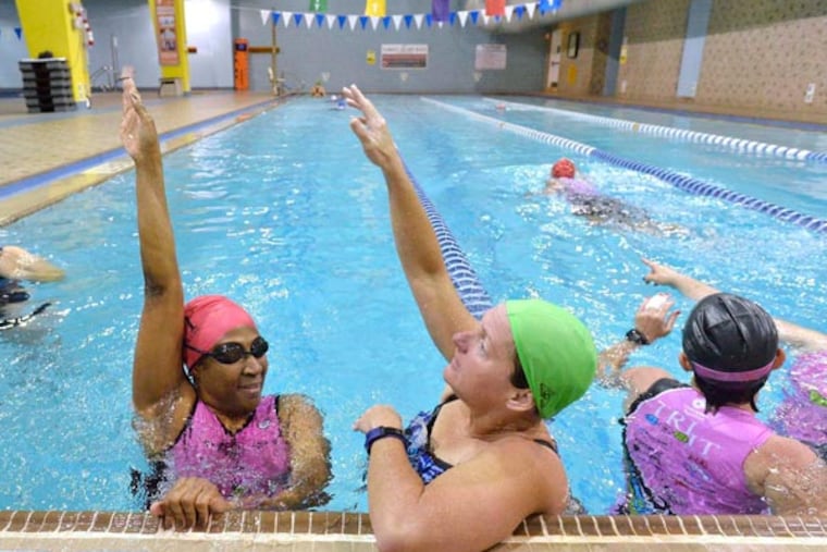 Try It For Life athlete Pam Christian, left, gets help with her backstroke from Try It For Life mentor Lisa McDaniel during a swim lesson on May 15,2014 at the Dowd YMCA in Charlotte, N.C. (Robert Lahser/Charlotte Observer/MCT)