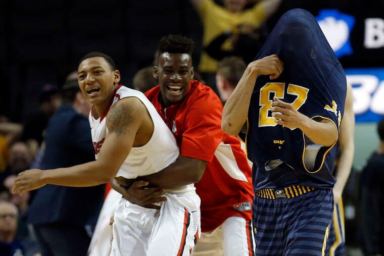 La Salle's Khalid Lewis can't bear to look as Davidson players celebrate.