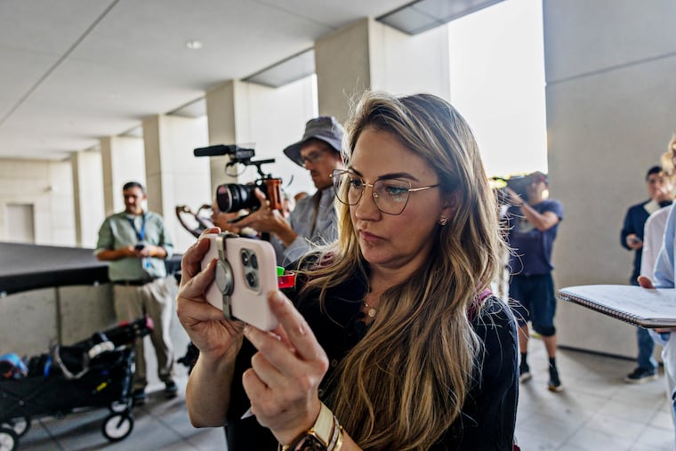 Keli Rabon, a podcaster from Houston, films outside the courthouse on the first day of a pre-trial hearing for Tyler Robinson, who was charged with killing Charlie Kirk, in Provo, Utah, July 6, 2026. Kirk’s assassination played out live on the internet, but since then, it has become fodder for fantasy.