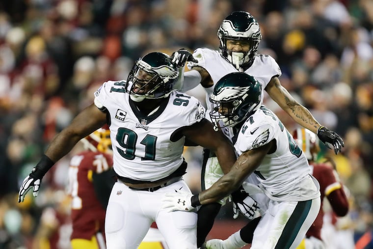 Fletcher Cox celebrates his fourth-quarter strip and sack on Washington quarterback Josh Johnson with Tre Sullivan (center) andMalcolm Jenkins.