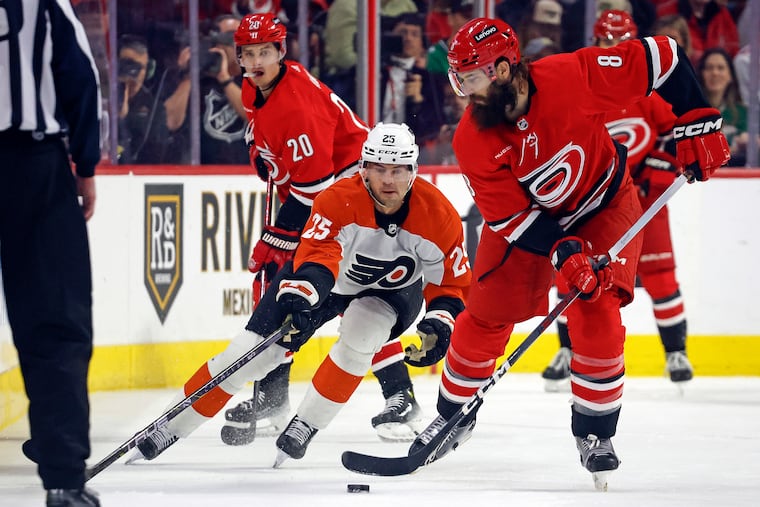 Carolina's Brent Burns controls the puck in front of the Flyers' Ryan Poehling.