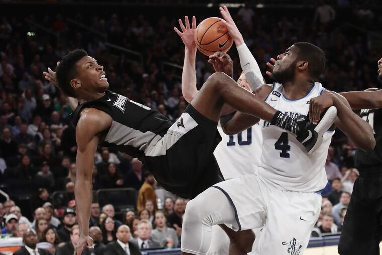 Providence's Rodney Bullock falling as Villanova's Eric Paschall (4) blocks his shot during the Big East title game.