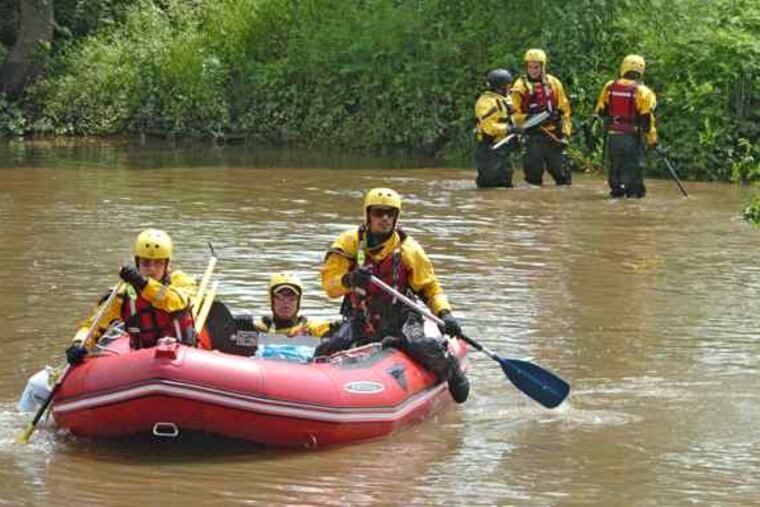 A search team plies the Brandywine after kayakers Christopher Miller, above left, and his brother Chad Miller drowned.