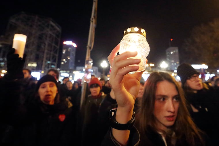 People hold lit candles in a memorial march for Gdansk Mayor Pawel Adamowicz in Warsaw, Poland, Monday, Jan. 14, 2019. People in Poland are gathering for solemn vigils to honor Gdansk Mayor Pawel Adamowicz, 53, who died Monday after being stabbed at a fund-raising event the night before. There were vigils in Warsaw and other cities across a nation shocked by the assassination.