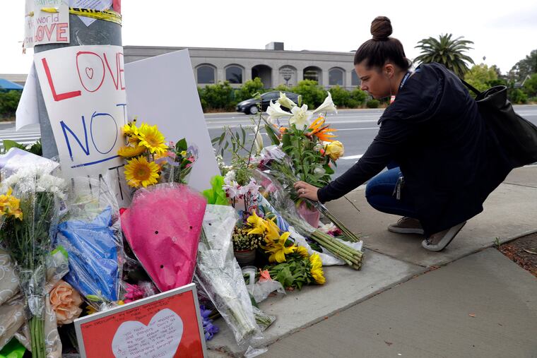 A woman leaves flowers on a growing memorial across the street from the Chabad of Poway synagogue in Poway, Calif., on Monday, April 29, 2019. A gunman opened fire on Saturday, April 27 as dozens of people were worshipping exactly six months after a mass shooting in a Pittsburgh synagogue.