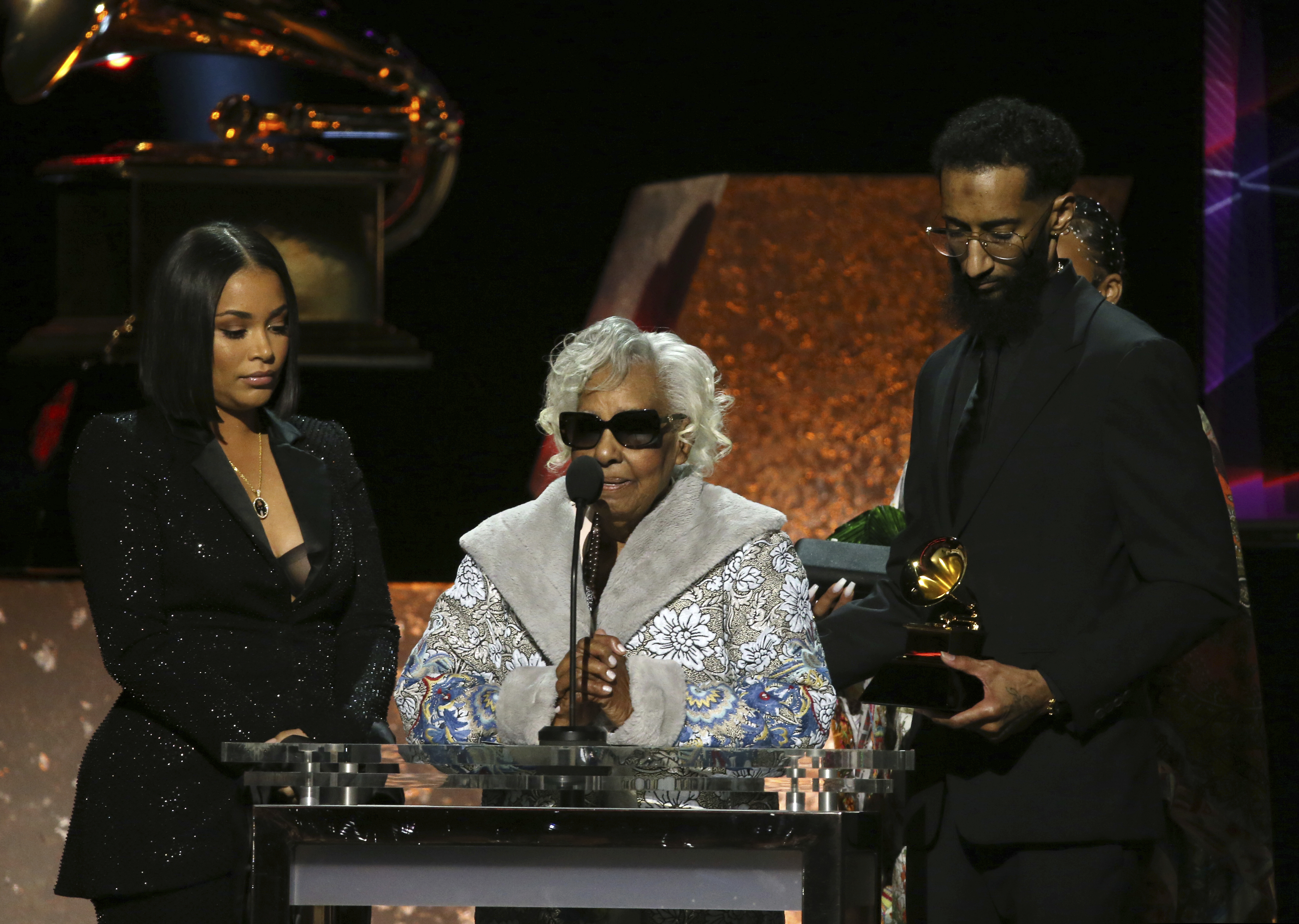 Lauren London, Margaret Boutte and Samiel Asghedom (from left to right) accept the award for best rap performance for "Racks in the Middle" on behalf of the late Nipsey Hussle.