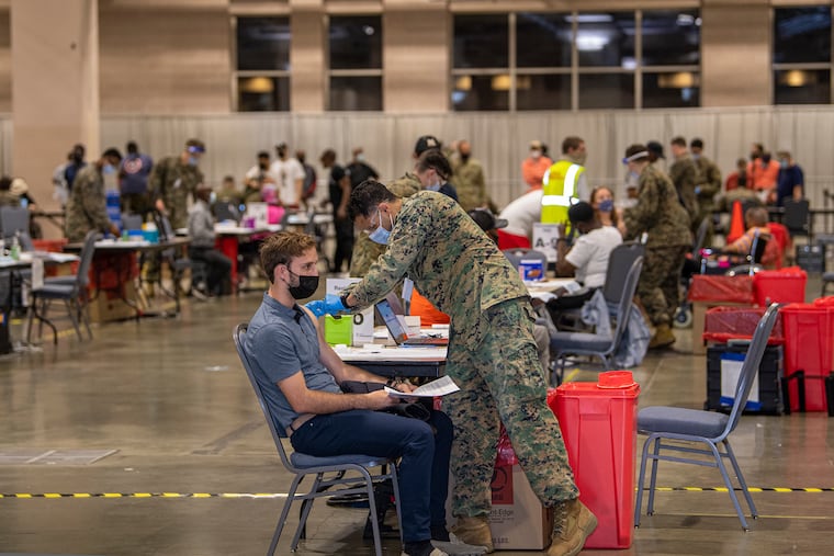 People get the COVID-19 vaccine at the FEMA vaccination clinic at the Philadelphia Convention Center last month. FEMA is turning over control of the operation to the city.
