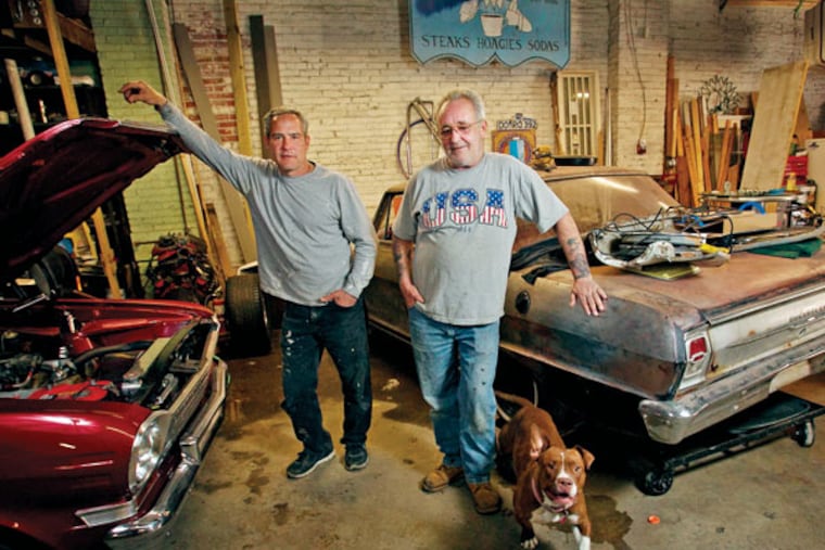 Billy “Ski” Braciszewski and Fred O’Rourke show two of their project cars in their garage at Front and Tasker. They have been victims of gentrification before, though they aren’t unwelcoming in their way to new faces. (ALEJANDRO A. ALVAREZ / Staff Photographer)
