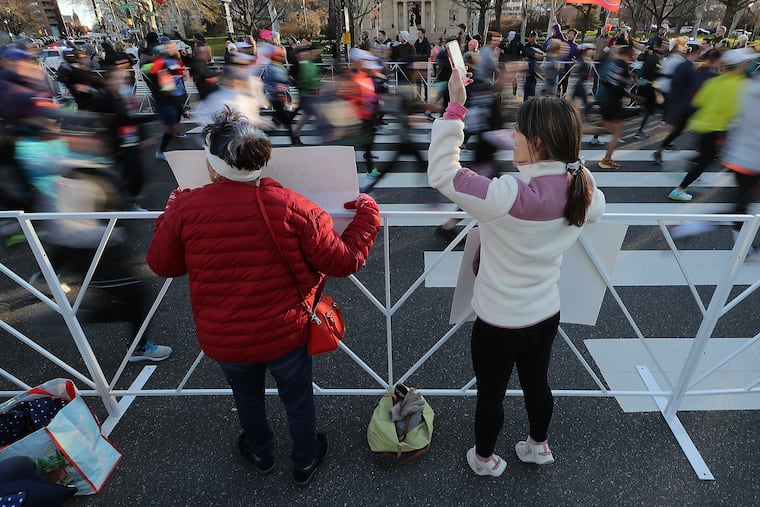 Jyo Lakkaraj (left) and Natalie Katchmar (right) cheer along the Ben Franklin Parkway during the Love Run Philadelphia Half Marathon in Philadelphia, Pa., on Sunday, March 27, 2022.