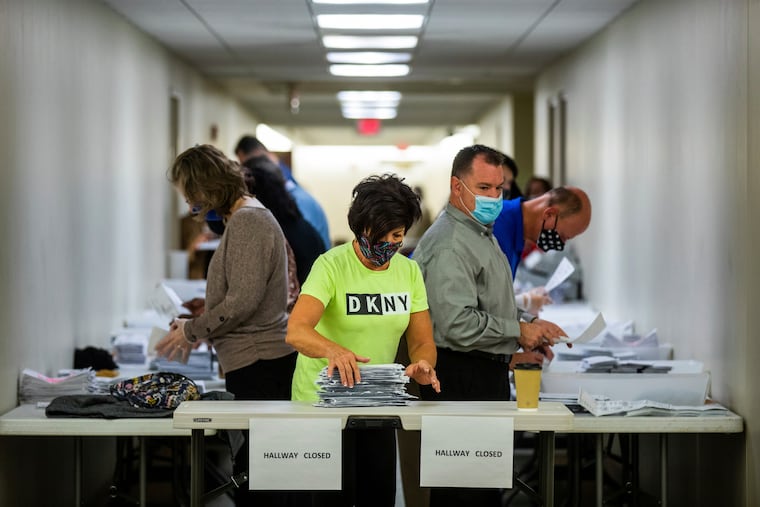 Jeri Shuits (center) office manager for the Beaver County Board of Elections, prepares ballots for counting in the basement of the Beaver County Courthouse on Wednesday in Beaver, Pa.