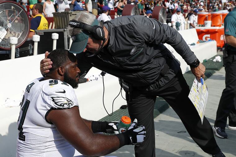 Philadelphia Eagles head coach Doug Pederson, right, speaks with defensive tackle Fletcher Cox in the final moments of an NFL football game against the Washington Redskins, Sunday, Sept. 10, 2017, in Landover, Md. Philadelphia won 30-17.