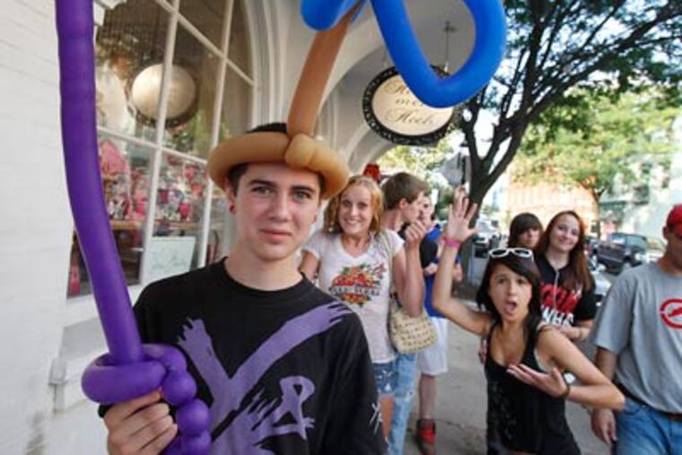 Festooned in balloons is Gavin Cigne, 14, along State Street. (Akira Suwa / Staff Photographer)