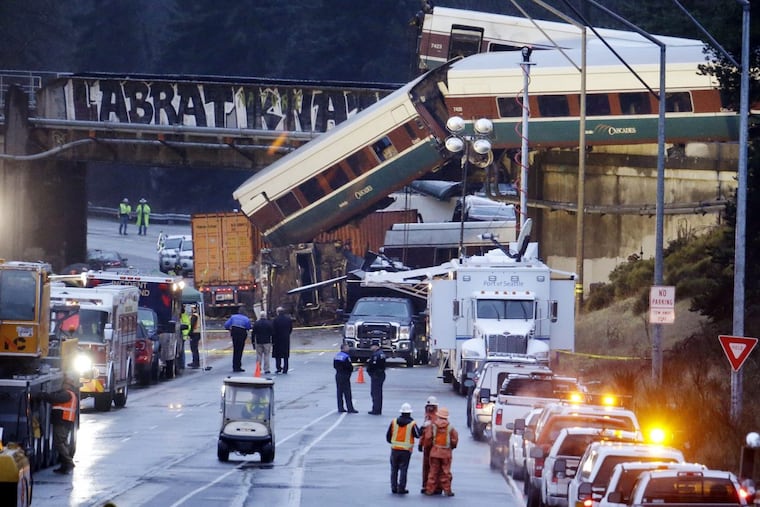 Lights illuminate cars from an Amtrak train that derailed above Interstate 5, Monday, Dec. 18, 2017, in DuPont, Wash. The Amtrak train making the first-ever run along a faster new route hurtled off the overpass Monday near Tacoma and spilled some of its cars onto the highway below, killing several people, authorities said. (AP Photo/Elaine Thompson)