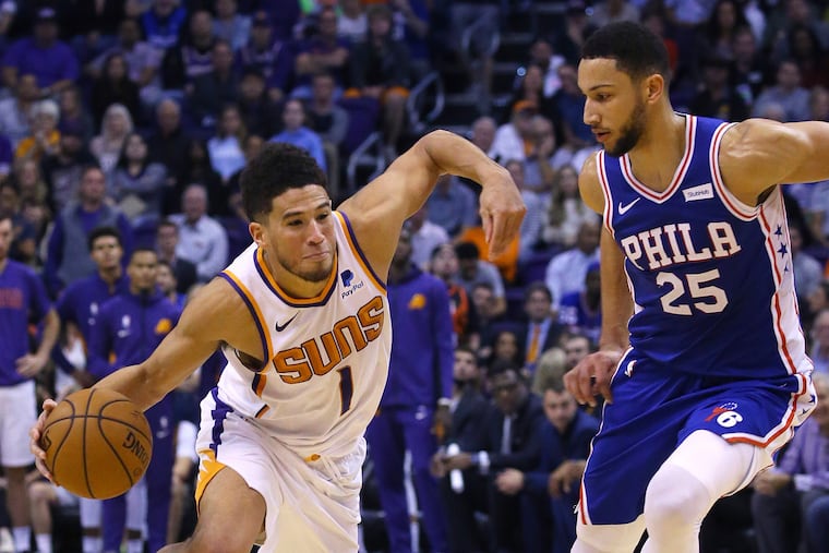 Phoenix Suns guard Devin Booker (1), here driving past Ben Simmons, torched the Sixers for 40 points Monday.