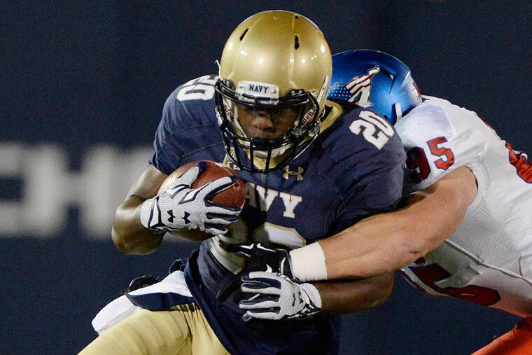 Navy Midshipmen running back Calvin Cass Jr. (20) runs as he is hit by Southern Methodist Mustangs defensive lineman Andrew McCleneghen (95) during the third quarter at Navy Marine Corps Memorial Stadium.