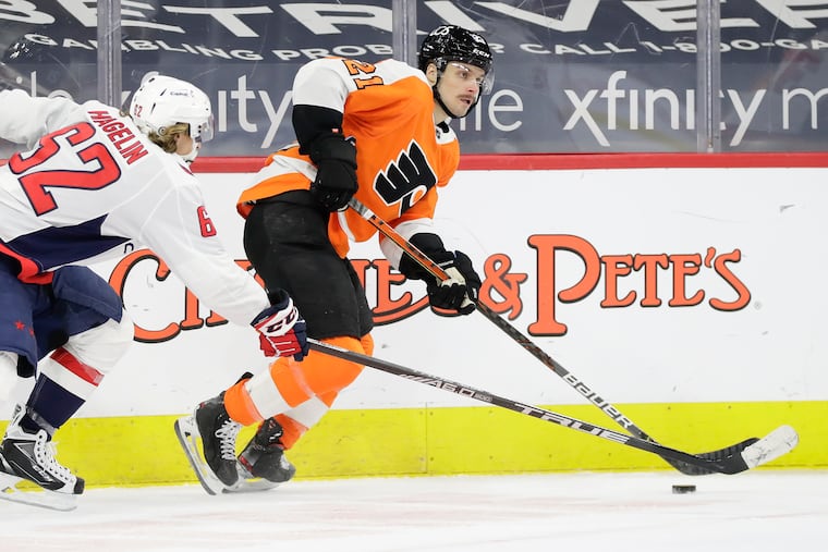 Flyers forward Scott Laughton skates after the puck past Washington Capitals left wing Carl Hagelin on Sunday. Laughton has raised his play the last two seasons and could be protected in the expansion draft.