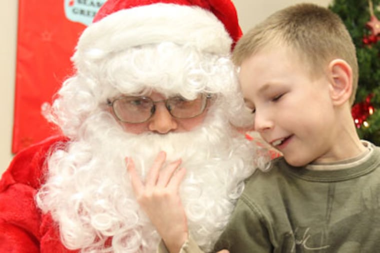 RELEASES HAVE BEEN SIGNED BY THE PARENTS/GUARDIANS OF THE HANDICAPPED CHILDREN. James Mayer, right, who is visually impaired, uses his hand to feel the beard of Santa Claus (Roy Spiller) after his morning of shopping for gifts. Each year, the Cherry Hill and Pennsauken Lions Club arrange for about 30 children, who are referred from the NJ Department of the Blind, to do their holiday shopping. Many of the children are multiple handicapped. Each child is given funds to get presents for their families and caregivers. The children come prepared with their shopping lists and are escorted around the store by teen volunteers who come from Camden and Burlington counties. ( Charles Fox / Staff Photographer )
