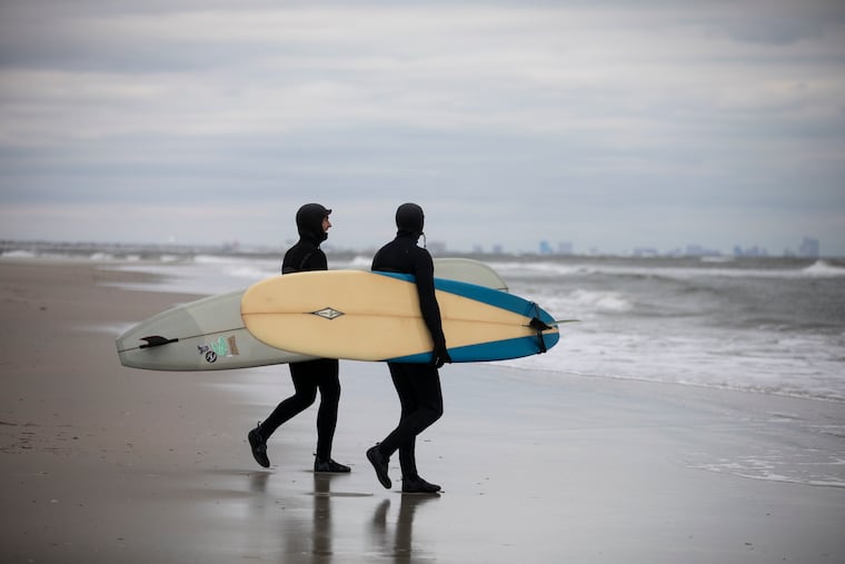 Chris Konicki and Clay Smith walk to the water at the beach at Willard Avenue in Strathmere, N.J., in 2021. Upper Township is considering instituting beach tags at Strathmere's beaches for the 2027 season.