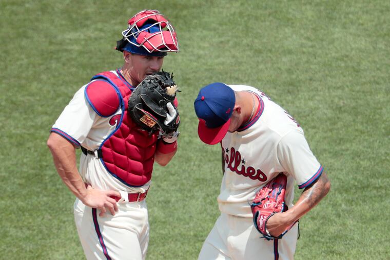 Phils catcher J.T. Realmuto (left) talked with pitcher Vince Velasquez in the second inning of Sunday's game against the Marlins.