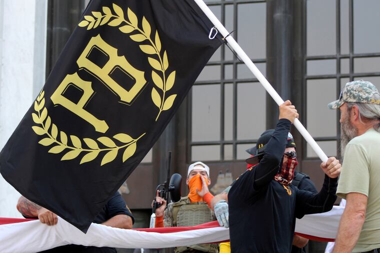A man carries a Proud Boys banner in front of the Oregon State Capitol in Salem, Ore., in September.
