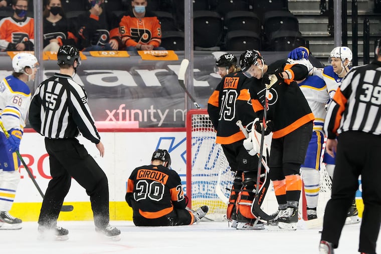 Flyers captain Claude Giroux sits on the ice as the Buffalo Sabres celebrate Jeff Skinner's goal that tied the score at 3-3 late in the third period Sunday. Buffalo won, 5-3.