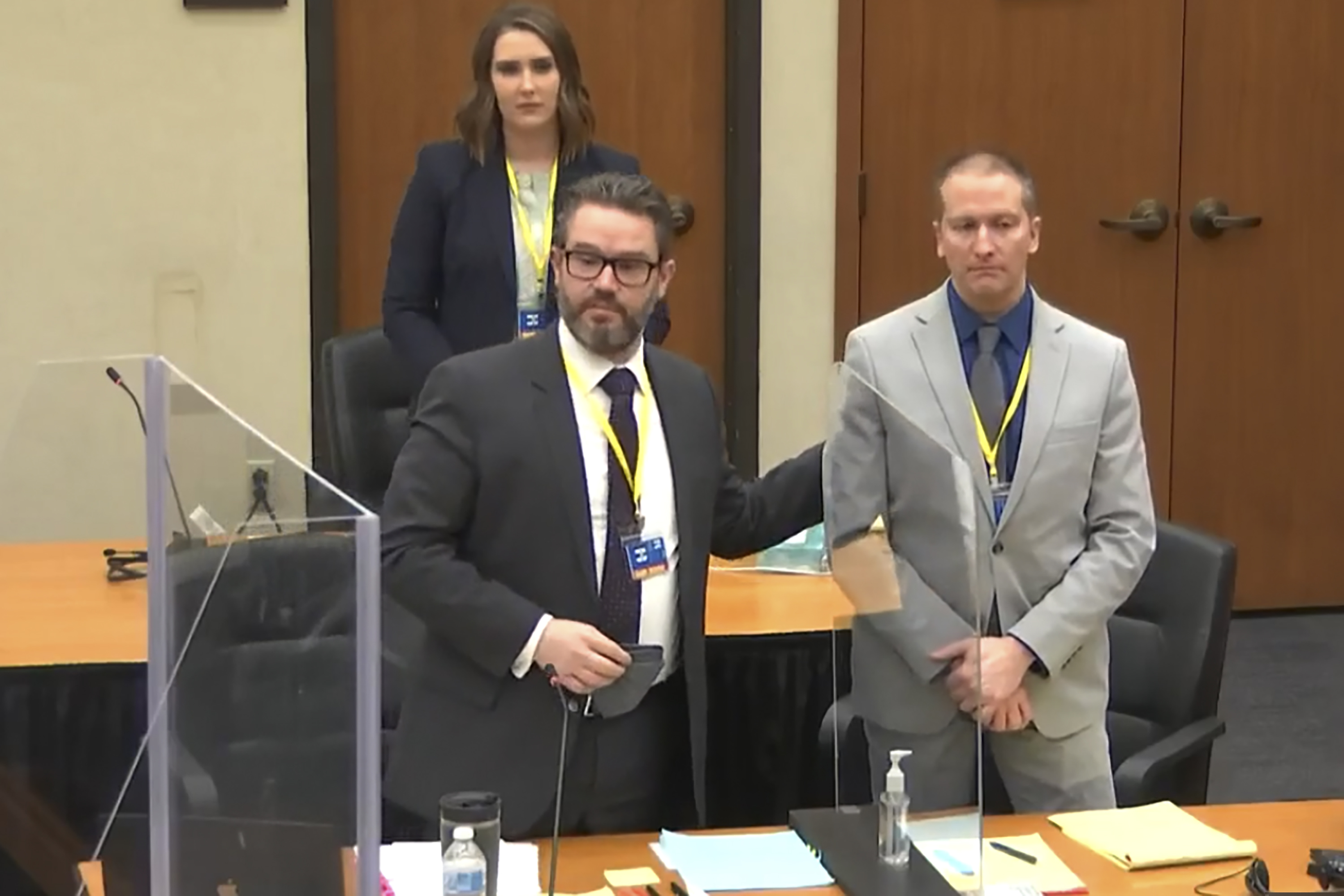 In this screen grab from video, defense attorney Eric Nelson, left, defendant and former Minneapolis police officer Derek Chauvin, right, and Nelson's assistant Amy Voss, back, introduced themselves to jurors as Hennepin County Judge Peter Cahill presided over jury selection in the trial of Chauvin on Wednesday at the Hennepin County Courthouse in Minneapolis.