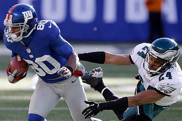 Nnamdi Asomugha tries to stop New York Giants' Victor Cruz during the first quarter on Sunday, December 30, 2012. (Yong Kim/Staff Photographer)