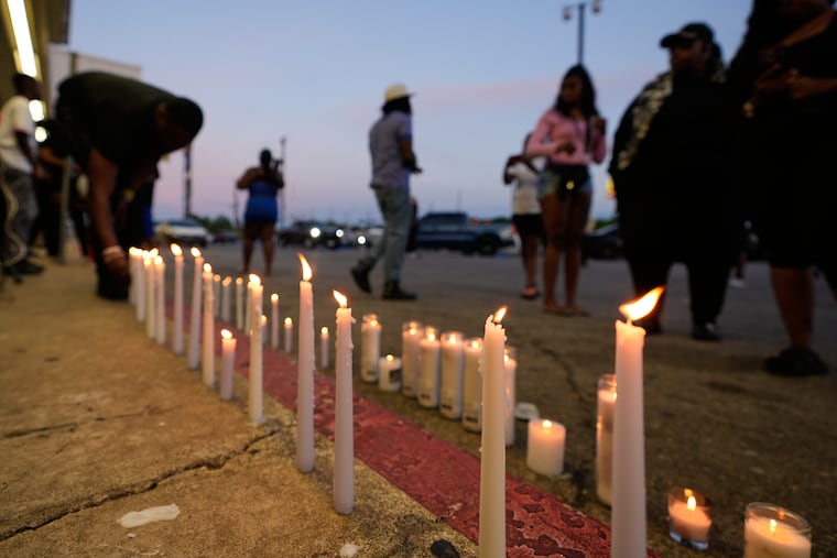 A man lights a candle during a prayer vigil for the victims of a mass shooting Sunday in Shreveport, La.