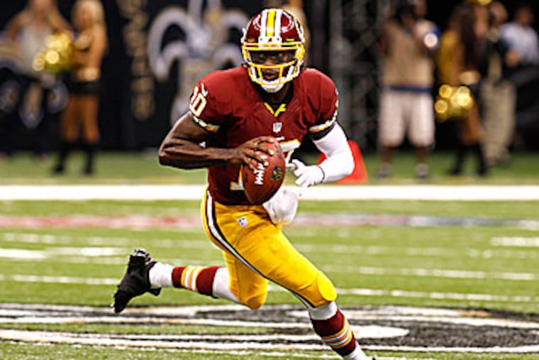 Redskins quarterback Robert Griffin III threw for 320 yards and two touchdowns against the Saints Sunday. (Bill Haber/AP)