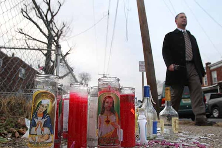 Investigator Michael Dougherty of the Camden County Prosecuter's Office, Homicide Unit, walks by the memorial that was created near the site where Dontae Perkins’ body was found on the 200 block of Grand Avenue in Camden with a bullet hole in his back and another under his armpit. It was the 65th homicide in Camden, NJ this year. ( Charles Fox / Staff Photographer )