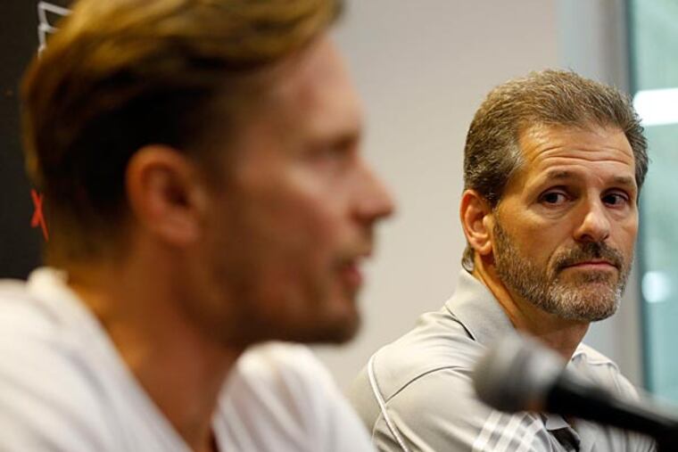 Ron Hextall listens to defenseman Kimmo Timonen during an update on Timonen's blood clot problems. (Yong Kim/Staff Photographer)